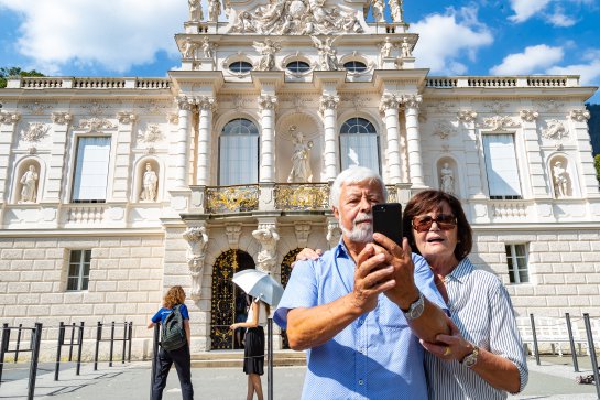 Mann und Frau machen Selfie vor Schloss Linderhof